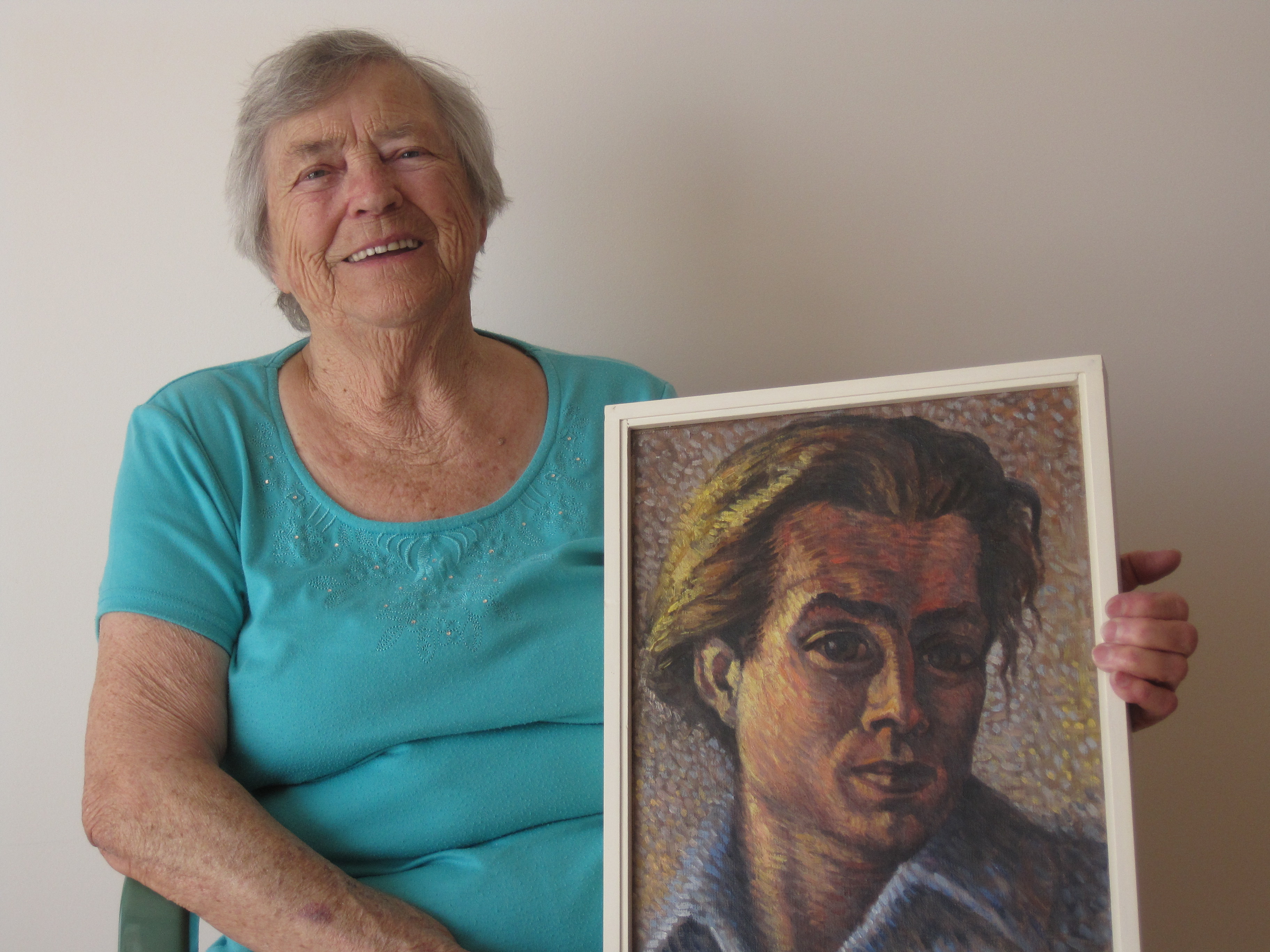 Dora Bakkenes holding a self-portrait of her late-husband Walter Bakkenes, 2014.
